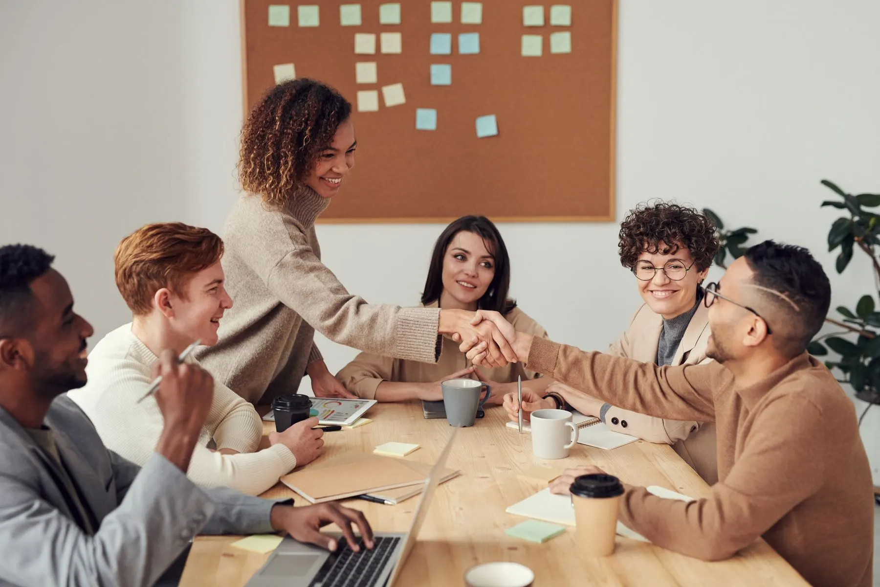 Equipo de trabajo reunido alrededor de una mesa durante una sesión de colaboración